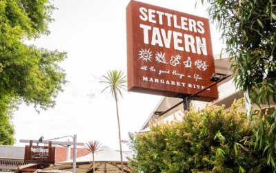 Settlers_Tavern_Food_OBJ886842 Street view of Settlers Tavern in Margaret River, with outdoor seating and greenery. Sign reads: "Settlers Tavern, all the good things in life.