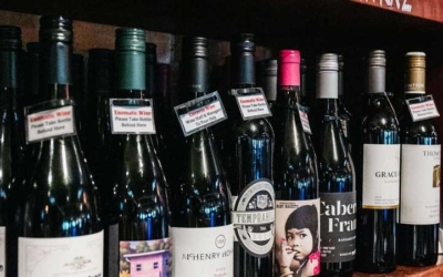 Settlers_Tavern_Food_OBJ886866 Shelves displaying various bottles of wine, labeled "Margaret River Shiraz" and "Wines by the Glass," with glasses stored below.