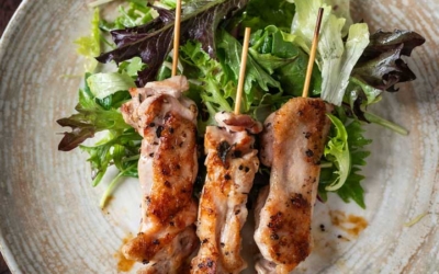 Settlers_Tavern_Food_OBJ887154 Three grilled chicken skewers on a plate with mixed greens.